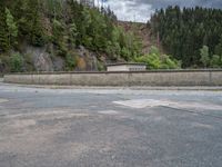 concrete walkway with trees and fenced in area on opposite sides of the road and one side of the road