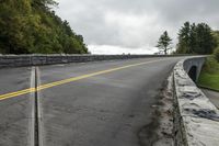 the roadway is paved with stones along both sides and is blocked off by a barrier