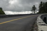 the roadway is paved with stones along both sides and is blocked off by a barrier