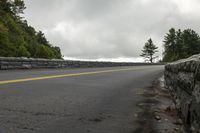 the roadway is paved with stones along both sides and is blocked off by a barrier