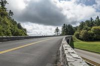 the roadway is paved with stones along both sides and is blocked off by a barrier