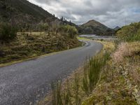 a road leading through an area with a lot of mountains in the background, and a highway is running through the field