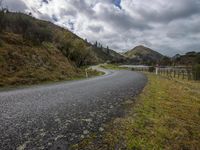 a road leading through an area with a lot of mountains in the background, and a highway is running through the field