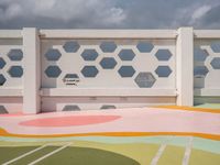 a colorful tiled outdoor space in front of the ocean with many geometric patterns, designed to match the sky's horizon