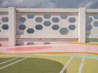 a colorful tiled outdoor space in front of the ocean with many geometric patterns, designed to match the sky's horizon