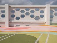 a colorful tiled outdoor space in front of the ocean with many geometric patterns, designed to match the sky's horizon