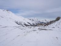a couple snowboards is laying in the snow on a road in front of mountains