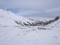 a couple snowboards is laying in the snow on a road in front of mountains