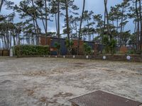 three buildings with trees and rocks behind them and in the foreground, there is a bench