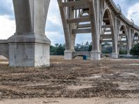 a construction site near an arch with a bridge crossing it and the building in the distance