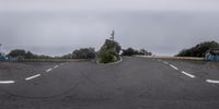 the view looking at a roundabout from the street in front of the trees and fence