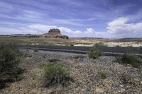 the empty road is going across the mountains in the desert, with mountains and hills