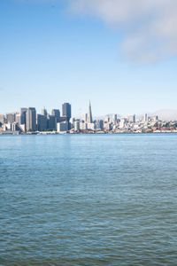 a large body of water surrounded by buildings and a city skyline on a bright day