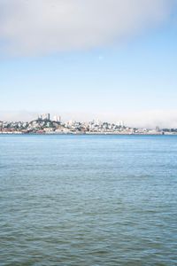 a large body of water surrounded by buildings and a city skyline on a bright day