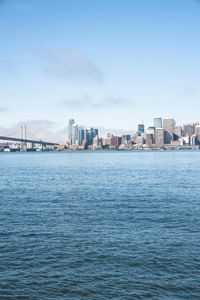 a large body of water surrounded by buildings and a city skyline on a bright day