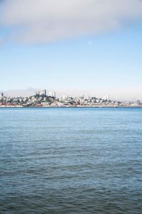 a large body of water surrounded by buildings and a city skyline on a bright day