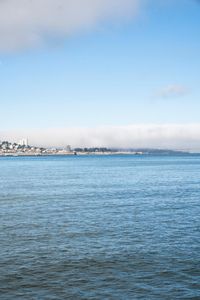 a large body of water surrounded by buildings and a city skyline on a bright day