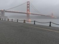 a white line marking on the street to the ground with a golden gate bridge in the background