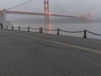 a white line marking on the street to the ground with a golden gate bridge in the background