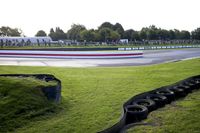 a race track with tire treads on grass and a fence around it to provide shade