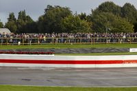 a race track with tire treads on grass and a fence around it to provide shade