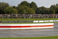 a race track with tire treads on grass and a fence around it to provide shade