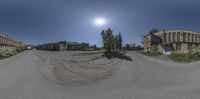 a fish eye photo of an empty street and buildings under a full moonlit sky