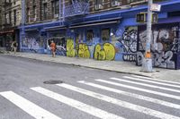 a crosswalk shows no traffic as many graffiti is painted on it's exterior