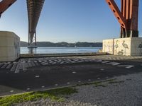 a long bridge spanning over water with graffiti painted across it and a sidewalk in between