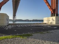 a long bridge spanning over water with graffiti painted across it and a sidewalk in between