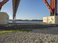 a long bridge spanning over water with graffiti painted across it and a sidewalk in between