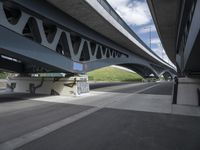 a large bridge with graffiti over a street that has a bicycle on the street next to it