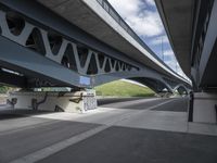 a large bridge with graffiti over a street that has a bicycle on the street next to it