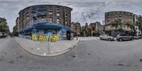 a circular lens shot shows a graffiti filled building next to a parking lot in an empty city