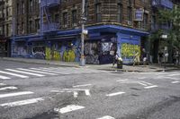 a building is painted with graffiti and is next to a street that is blocked off in