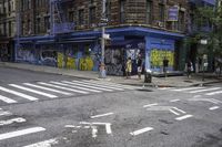 a building is painted with graffiti and is next to a street that is blocked off in