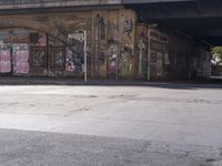 the brick building is covered in graffiti and posters and signs of various names on the side of the street