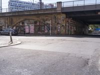 the brick building is covered in graffiti and posters and signs of various names on the side of the street