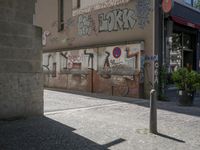 the building is covered with graffiti and signs on the outside of the building it is next to a sidewalk with no cars