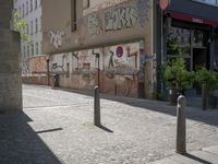 the building is covered with graffiti and signs on the outside of the building it is next to a sidewalk with no cars