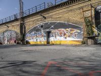 a building covered with lots of different graffiti paint on it's exterior wall next to a brick road