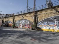 a building covered with lots of different graffiti paint on it's exterior wall next to a brick road