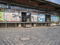 the train station is covered in graffiti and art as well as parked motorcycles and buses