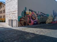 a graffiti filled street with buildings and brick sidewalks on the corner of a cobblestone road