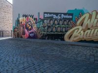 mural of beer being painted on a wall with people walking by it at a sidewalk