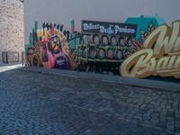 mural of beer being painted on a wall with people walking by it at a sidewalk