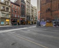 a view of a city street with graffiti all over the sidewalks and the buildings behind it