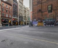 a view of a city street with graffiti all over the sidewalks and the buildings behind it