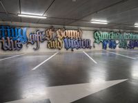 graffiti is shown on the wall of a parking garage in this image from inside a car park