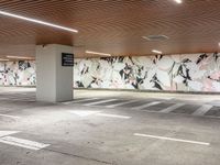 a concrete parking lot in an empty space with painted murals on the walls and ceiling